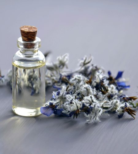 Close-up of a lavender oil bottle with dried flowers for aromatherapy. Perfect for wellness themes.